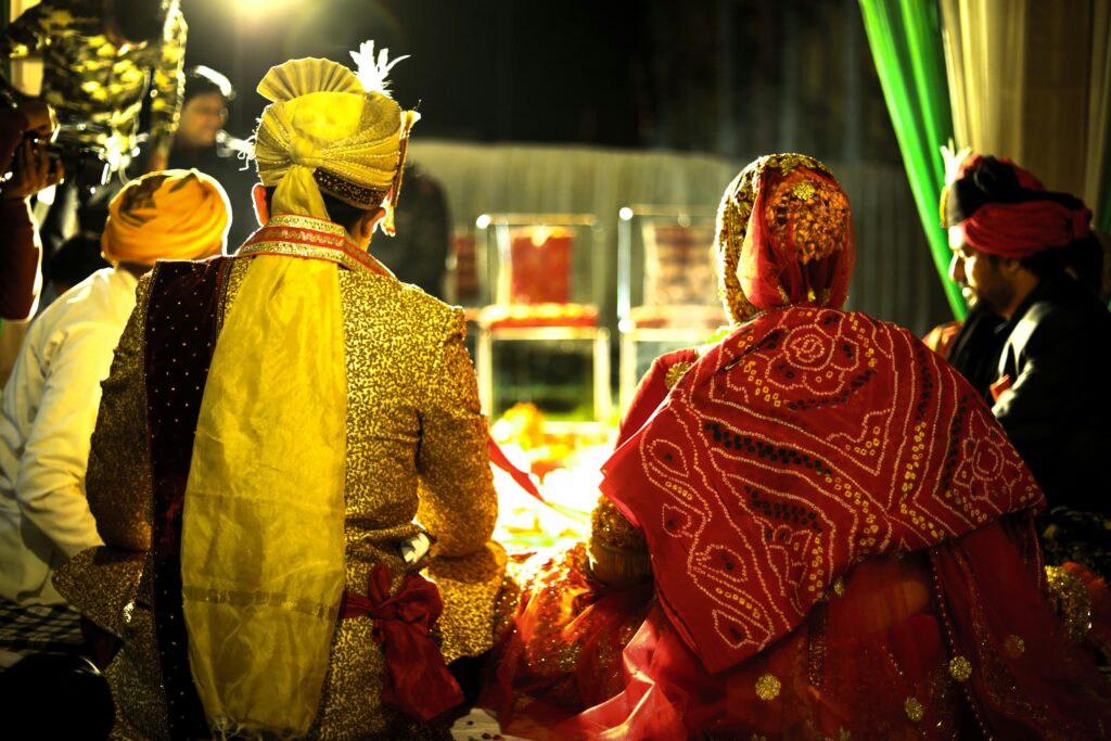 Colorful Indian bride and groom at a traditional wedding ceremony during the night.